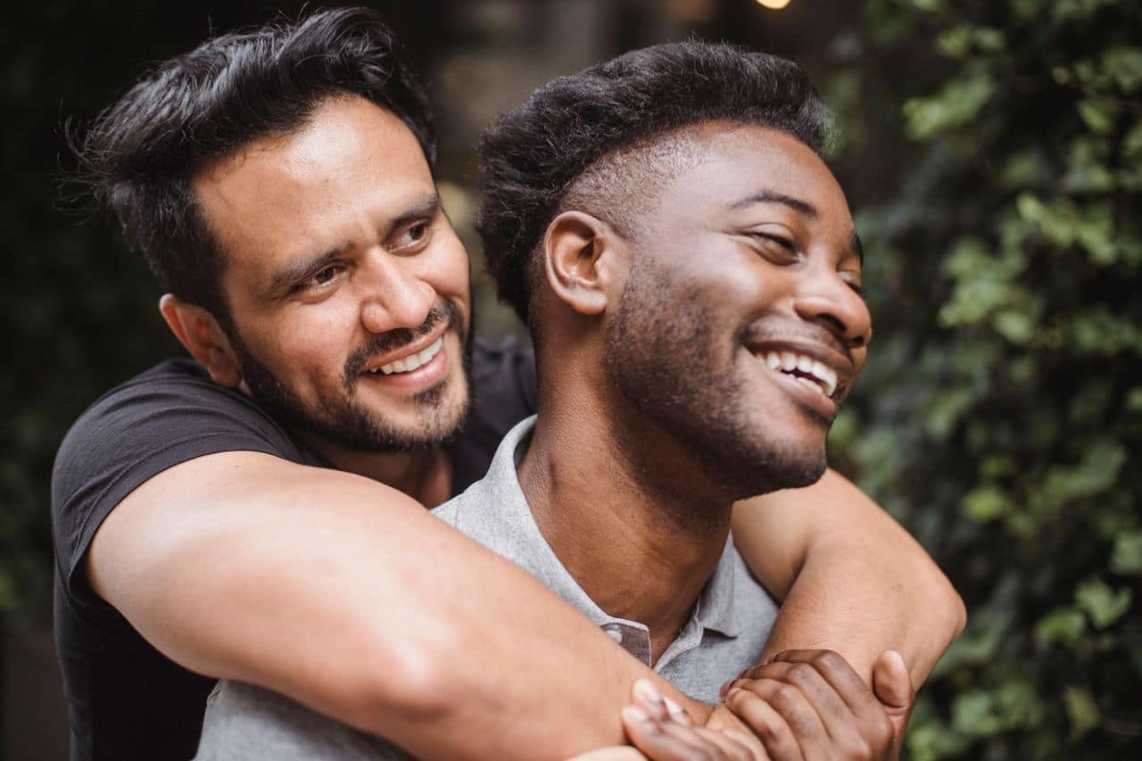 A happy couple hugging outdoors, showcasing love and affection.